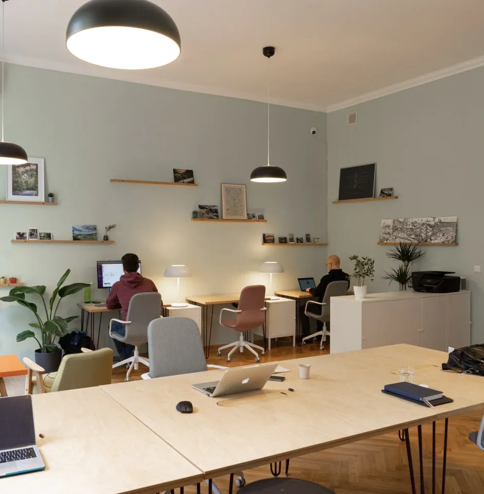 Image of two team members working at their desks